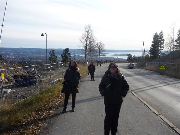 Two women walk along the road above the Oslofjord