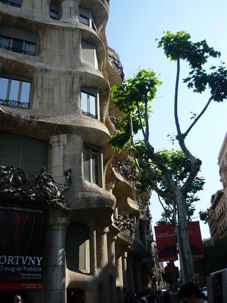 La Pedrera di Gaudí, facciata ondulata in pietra tra gli alberi