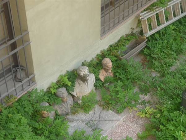 Busti di pietra semiadossati alla parete, avvolti dal verde, Barcellona