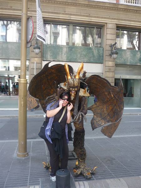 Turista spaventata accanto a un artista travestito da drago, Rambla, Barcellona