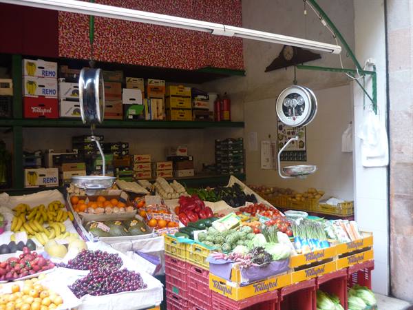 Banchi di frutta fresca e bilance appese al mercato di Barcellona
