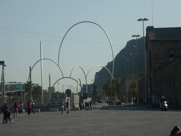 Calatrava's steel arches before Montjuïc, people walk across the square