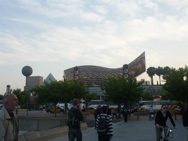People near Gehry's metal fish sculpture in Barcelona
