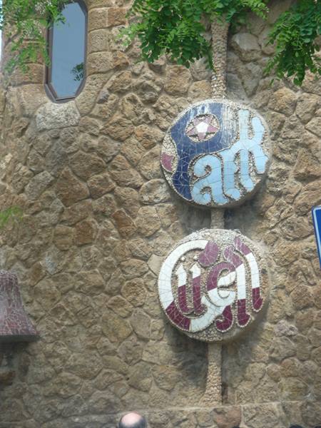 Mosaic signs reading Park Güell on Gaudí's stone wall