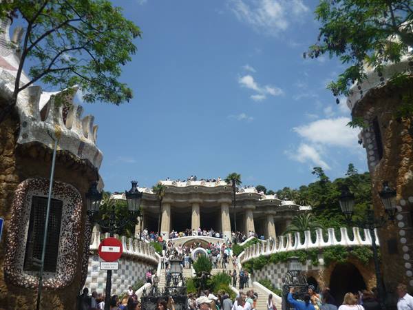 Tourists on the mosaic staircase at Park Güell, Barcelona, stone pavilions
