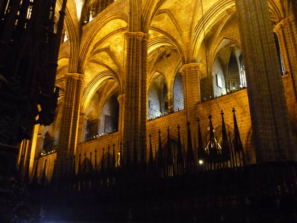 Gothic stone vaults lit in golden light inside a cathedral