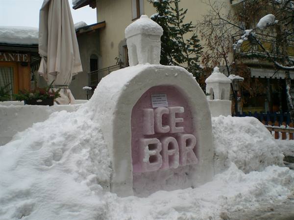 Snow sculpture bar reading Ice Bar, in a snowy mountain village