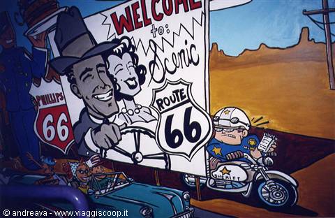 Route 66 cartoon mural with motorcycle cop and welcome sign