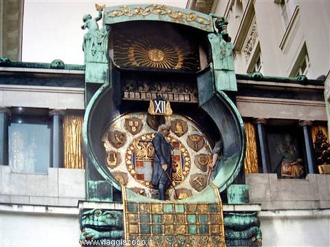 The Anker Clock in Vienna: marble figure before the golden dial, oxidized copper