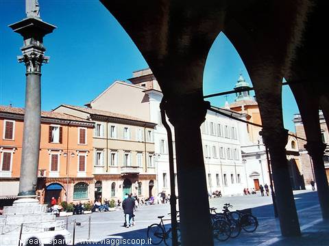 Ancient column and bicycles under Ravenna arcades in bright sunlight