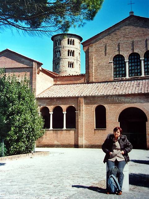 Woman sitting in front of Sant'Apollinare in Classe basilica, brick facade and bell tower