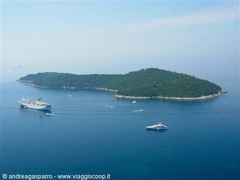 Lokrum island covered in green, ferry and yachts sailing the Adriatic
