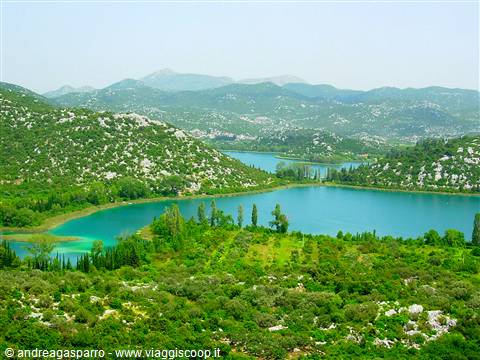 Turquoise lakes among green hills and cypress trees in Dalmatian countryside