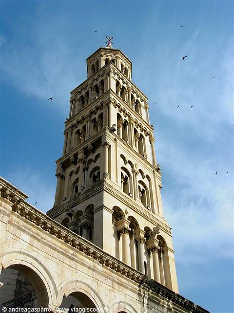 Romanesque stone bell tower of Diocletian in Split, birds against blue sky