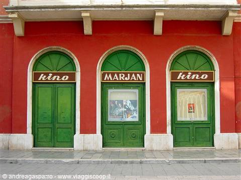 Red facade of Marjan cinema in Split, sage-green doors and kino signs