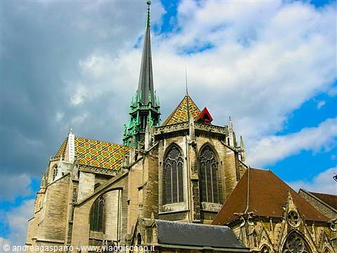 Gothic cathedral in Dijon with polychrome glazed tile roof under white clouds