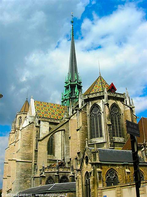 Gothic Saint-Bénigne cathedral in Dijon, colorful tiled roof, green spire under clouds