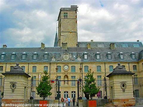 Stone facade with medieval tower and wrought-iron gates in Dijon