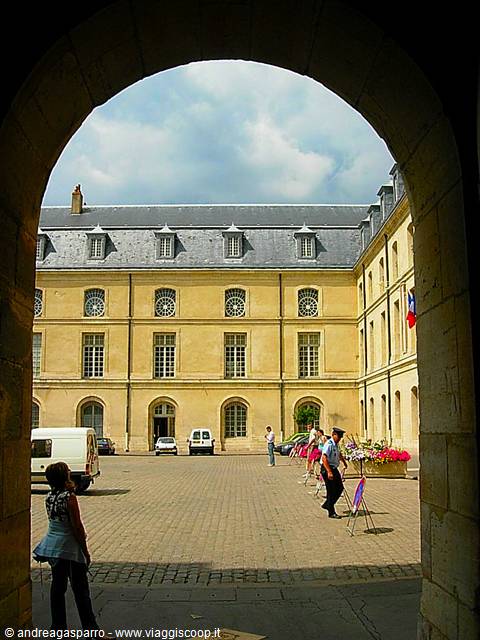 Inner courtyard of a yellow building framed by a stone arch