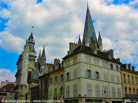 Notre-Dame church and old houses in Dijon under white clouds