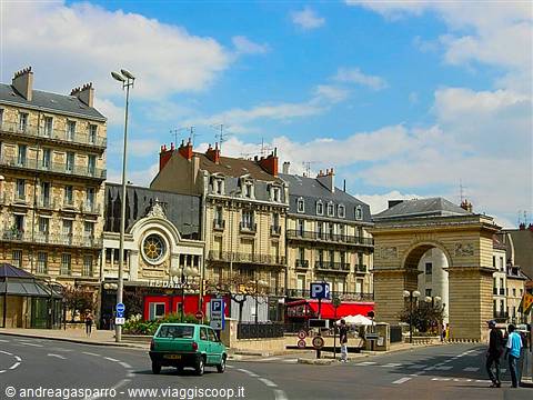 Porte Guillaume in Dijon: stone arch among buildings, cars and pedestrians