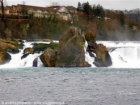 Rhine Falls, rocky islet with Swiss flag and castle behind