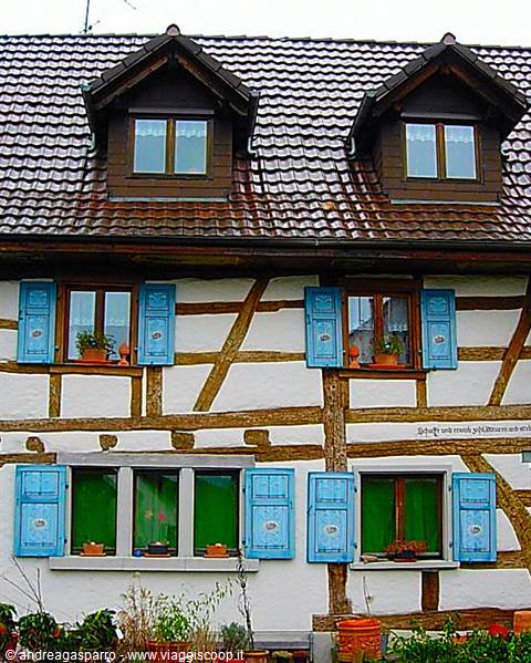 Half-timbered house with blue shutters and tiled roofs