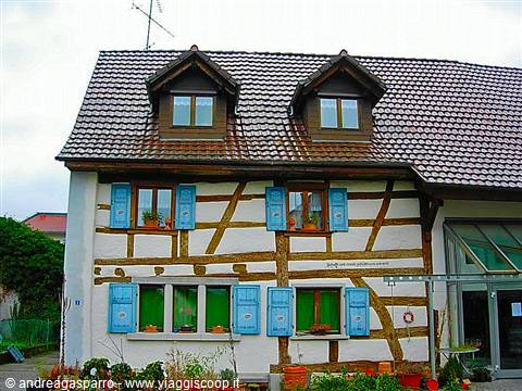 Half-timbered house with tiled roofs and blue shutters in Appenzell