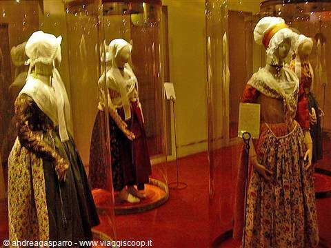 Mannequins wearing traditional Sardinian costumes inside lit plexiglass display cases