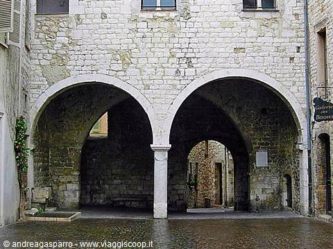 White stone arched loggia on medieval square, natural daylight