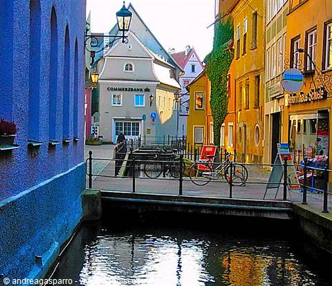 Bicycle on a bridge over a canal among colorful facades, Füssen