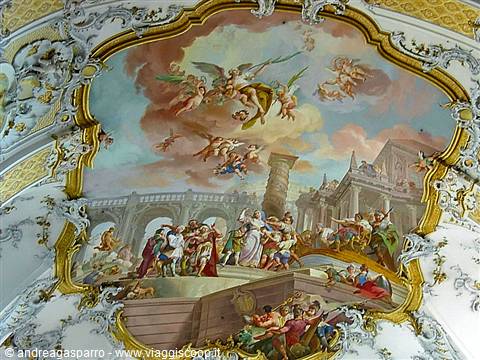 Baroque fresco with angels and crowded figures framed by gilded stucco