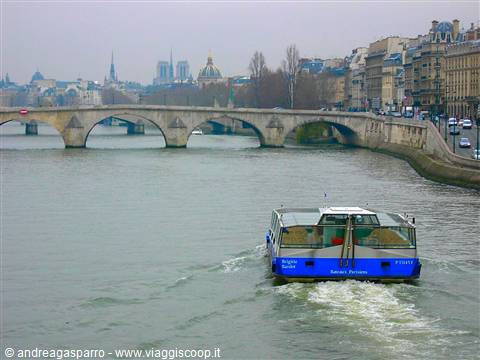 Blue bateau mouche sails the Seine under Pont-Neuf, Paris
