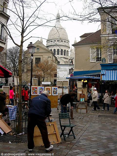 Painters with easels on Place du Tertre, the Sacré-Cœur dome rising behind houses