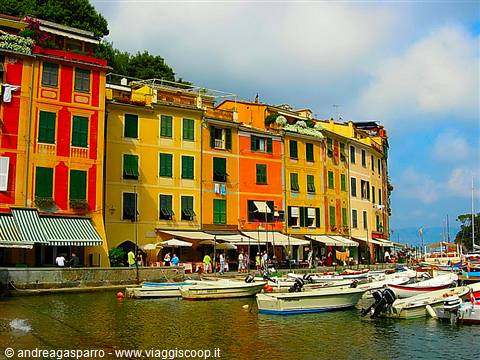 Colorful houses on Portofino harbor, moored boats and crowded waterfront