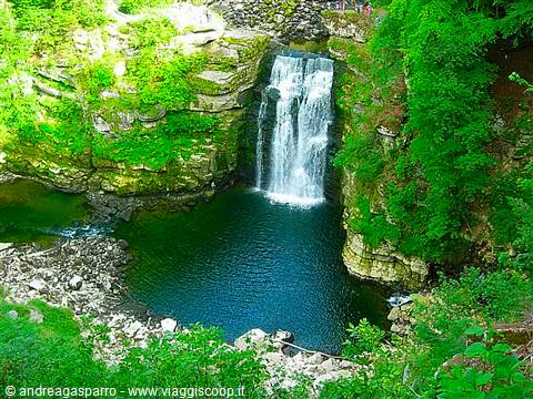 Waterfall plunging over mossy rocks into a turquoise pool