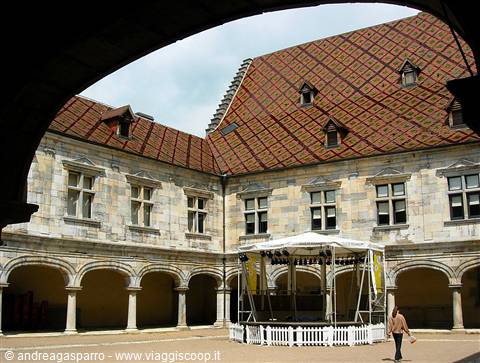 Courtyard of the Hospices de Beaune with polychrome tiled roof and arcades