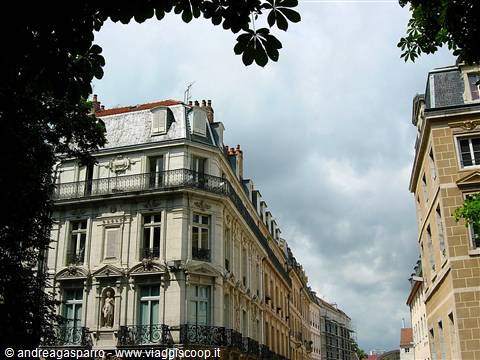 19th-century buildings with wrought-iron balconies under a cloudy sky