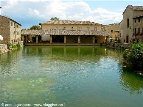 The thermal pool of Bagno Vignoni surrounded by ancient stone buildings