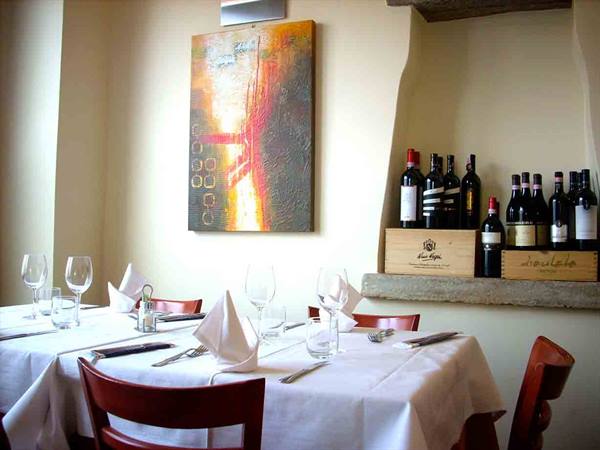 Restaurant dining room with white tablecloths, wine glasses and bottles