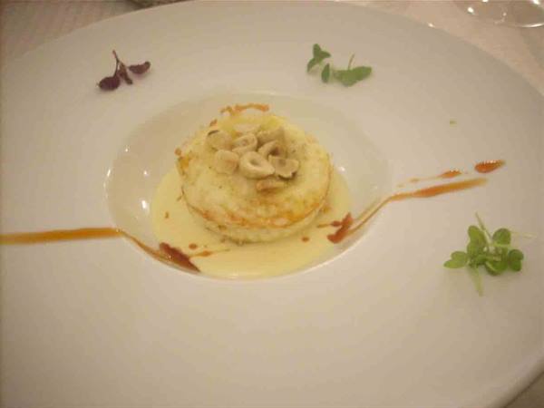 Egg in shape with runny yolk on Grana Padano zabaglione and toasted hazelnuts