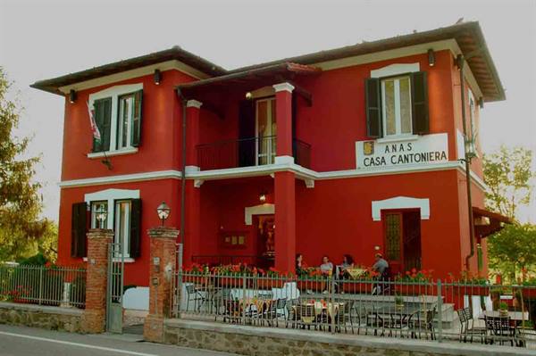 Red Anas Casa Cantoniera building with people seated at outdoor tables