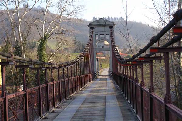 Ponte Gobbo in Bobbio, stone and iron footbridge with entrance tower among hills