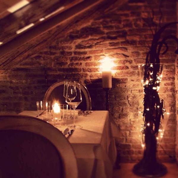 Set table with glasses and candles in a brick-walled attic