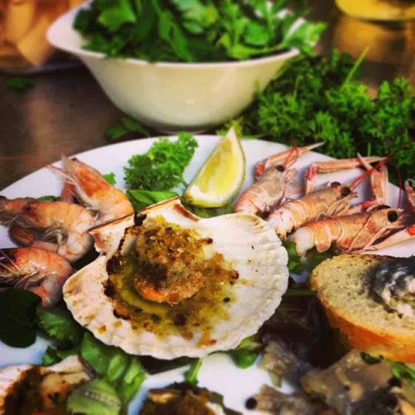 Buttered scallop on the shell with langoustines, prawns, lemon and fresh parsley