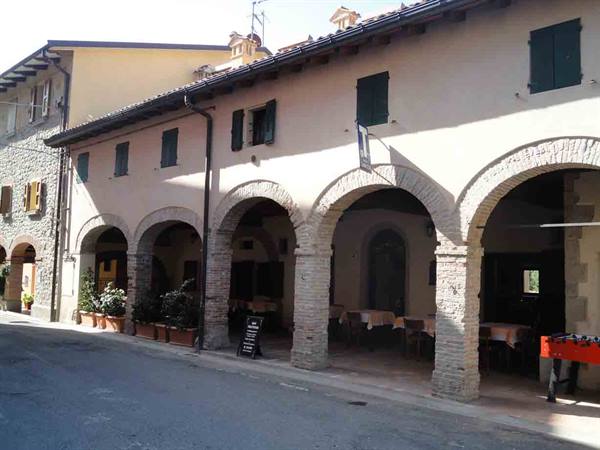 Brick arcades with set tables along the village street