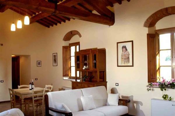 Rustic living room with wooden beams, white sofa, cabinet and dining table