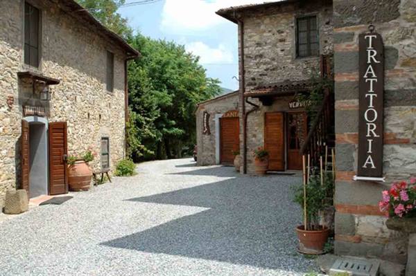 Stone village with gravel lane and trattoria sign