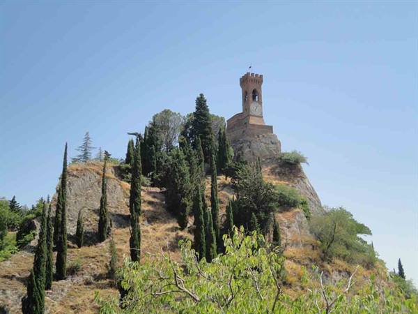 Brick clock tower on rocky hill among cypresses, Brisighella
