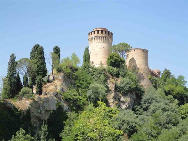 Brisighella's Rocca Manfrediana, round stone tower amid cypress trees